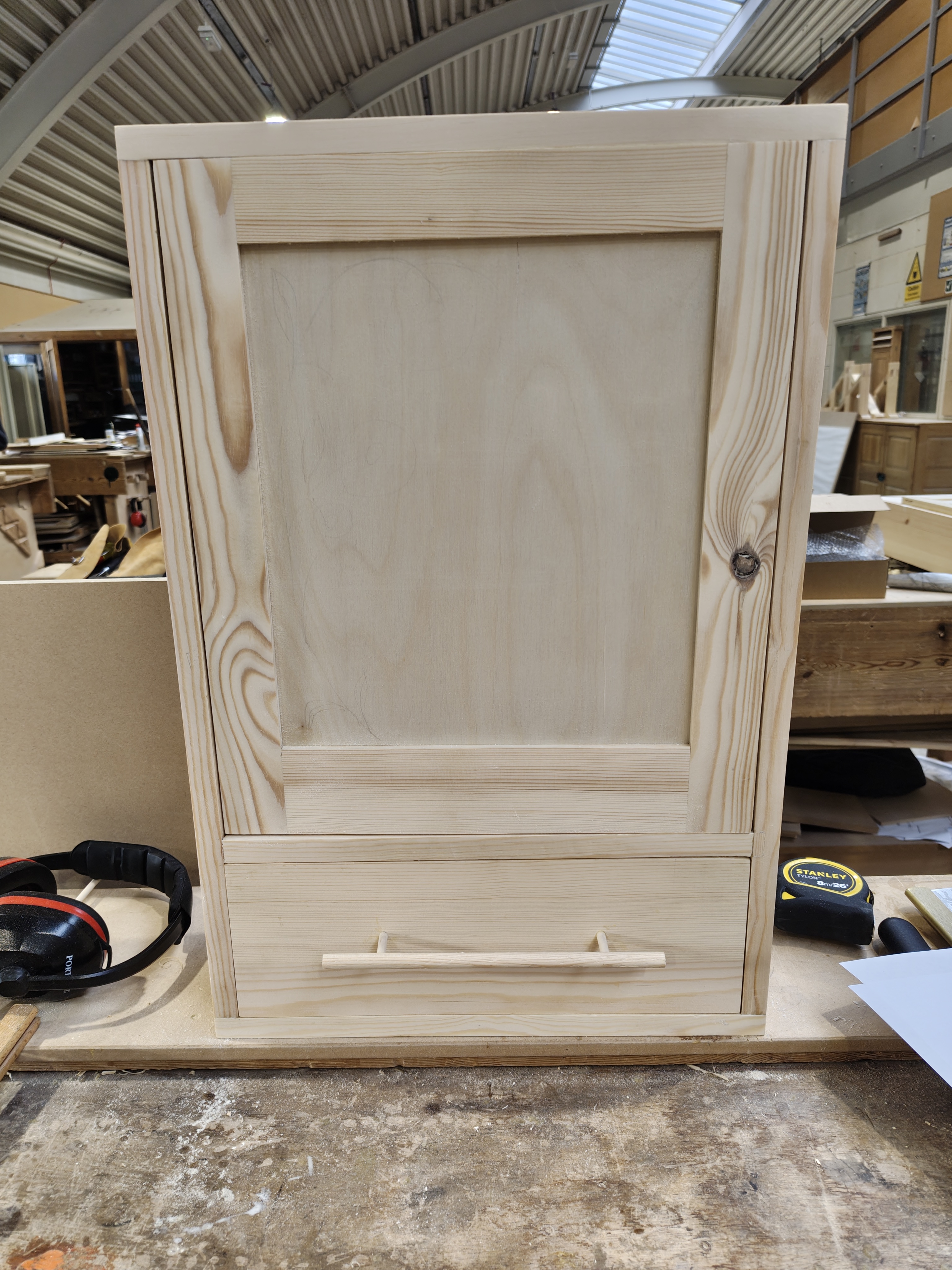 Pine cabinet — front view with framed door and drawer